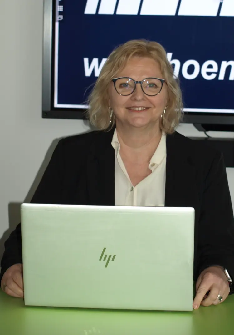 Personalerverantwortliche Manuela Pöttrich vor einem Bildschirm mit Hönisch Bau GmbH Hintergrund illustriert die Karriere